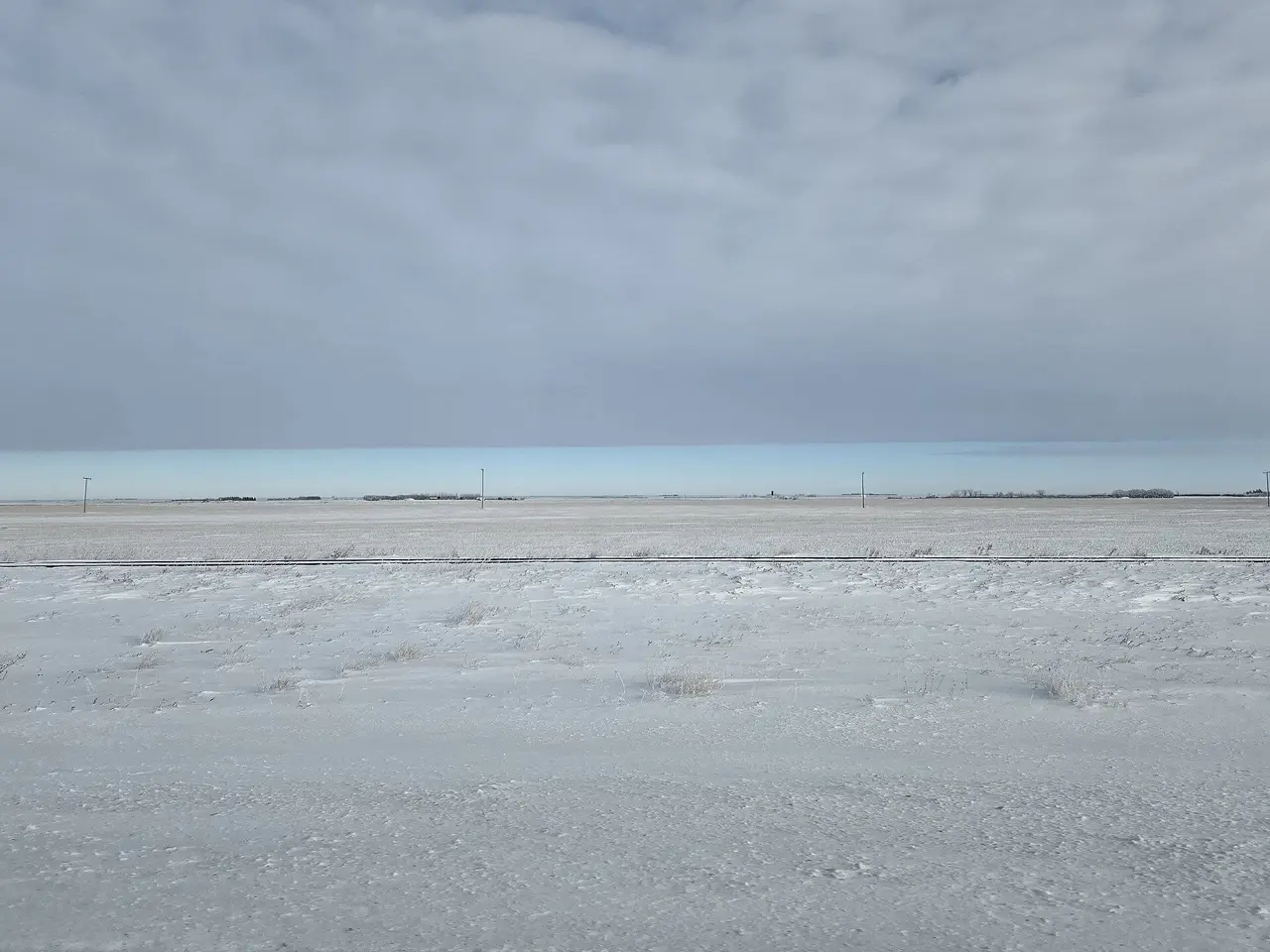 Snowy prairie fields and railway line, 2024